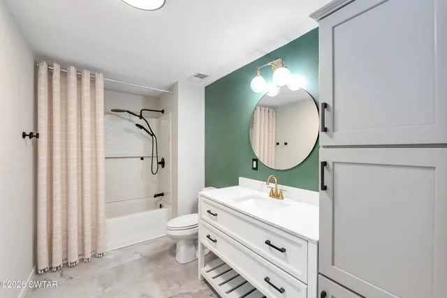a bathroom with a sink mirror and a toilet