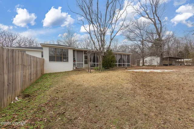 a view of a yard with a house and a large tree