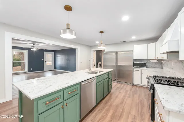 a kitchen with stainless steel appliances granite countertop a sink stove and refrigerator