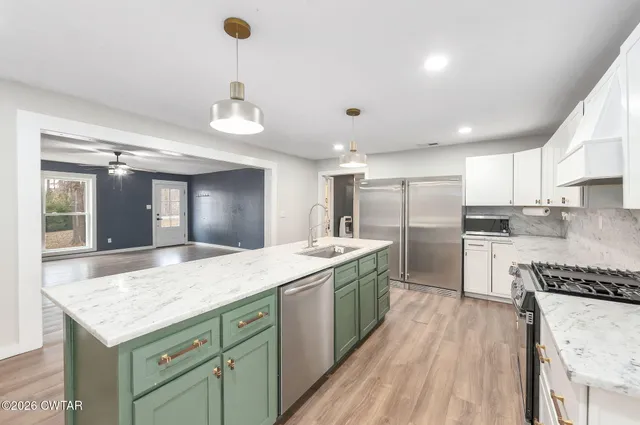 a kitchen with stainless steel appliances granite countertop a sink stove and refrigerator