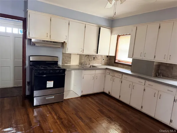 a kitchen with cabinets appliances and a window