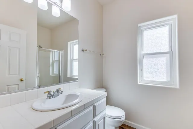 a bathroom with a sink vanity mirror and toilet