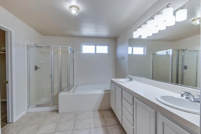 a bathroom with a tub a sink and a mirror