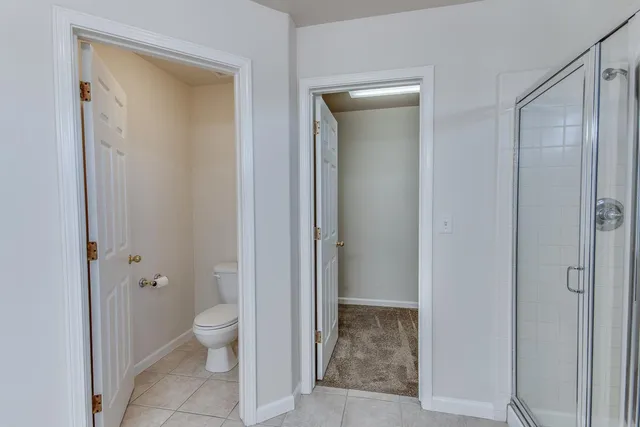 a bathroom with a granite countertop toilet a sink and shower