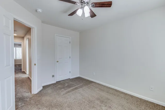 an empty room with chandelier fan