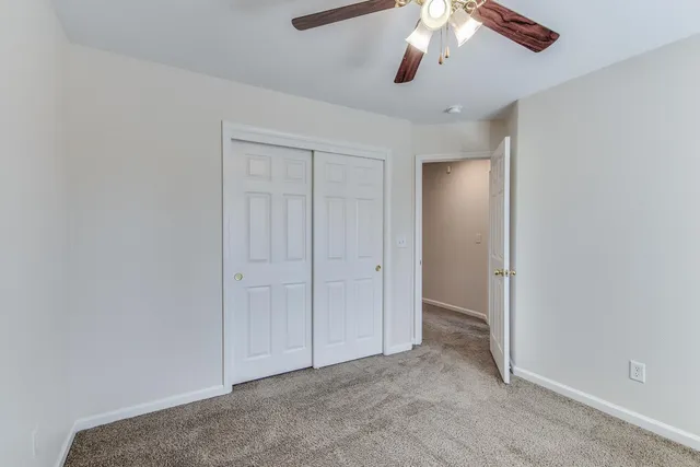 an empty room with chandelier fan