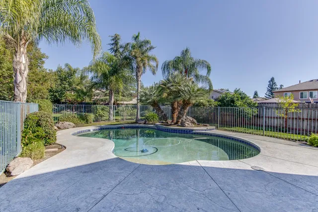 a view of a swimming pool with a patio and a garden