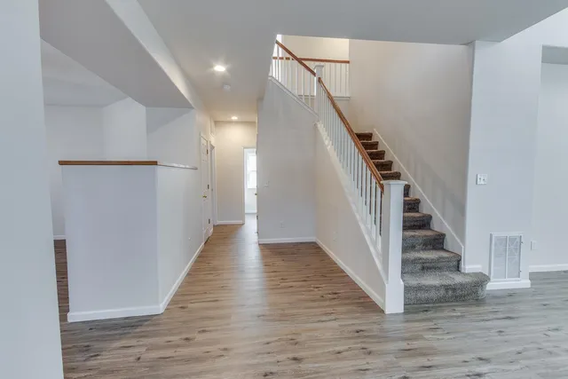 a view of entryway and hall with wooden floor