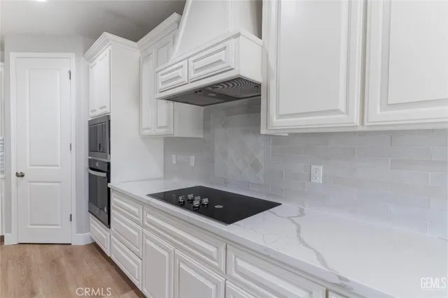 a kitchen with a stove and white cabinets
