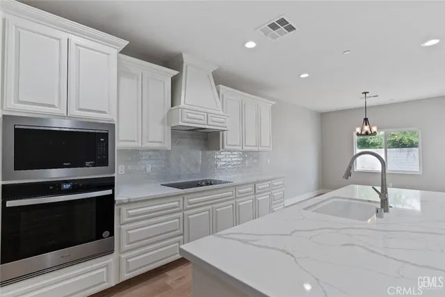 a kitchen with white cabinets appliances and a sink