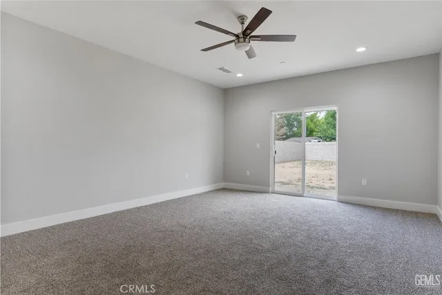 an empty room with windows and ceiling fan
