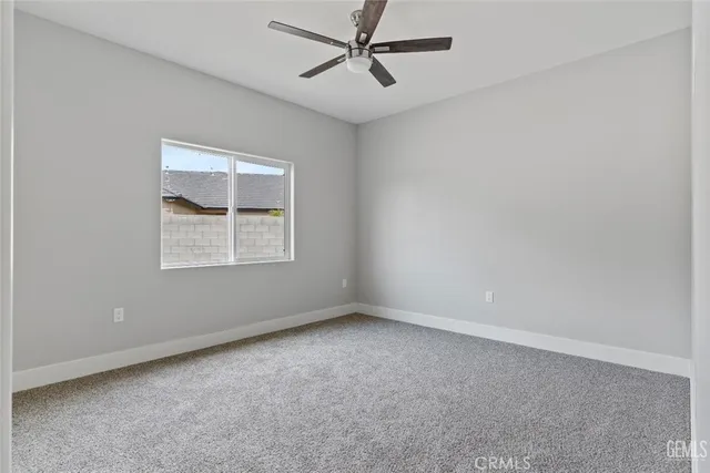 an empty room with a window and ceiling fan