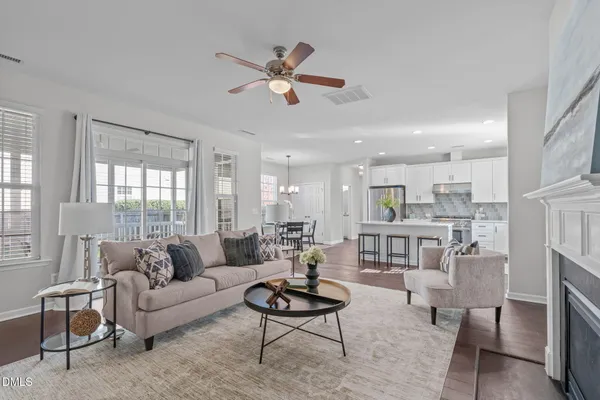 a living room with furniture kitchen view and a large window