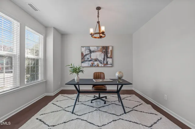 a view of a workspace with furniture and a window