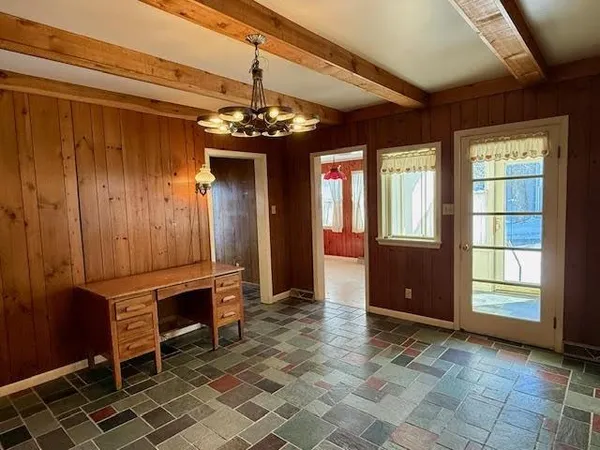 a view of a livingroom with a fireplace a chandelier and windows