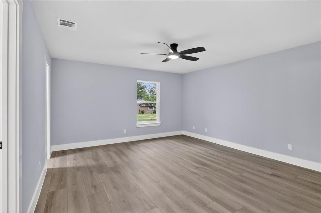 2005 Chestnut Road Carrollton, TX 75007 - Photo 24 of 35 an empty room with wooden floor and windows