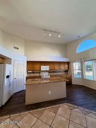 a living room with stainless steel appliances kitchen island granite countertop a stove and a refrigerator