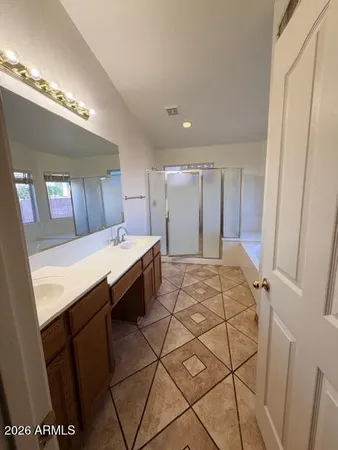 a spacious bathroom with a double vanity sink and a mirror