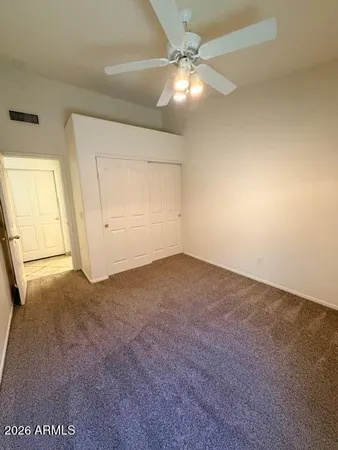 an empty room with an entryway and fan