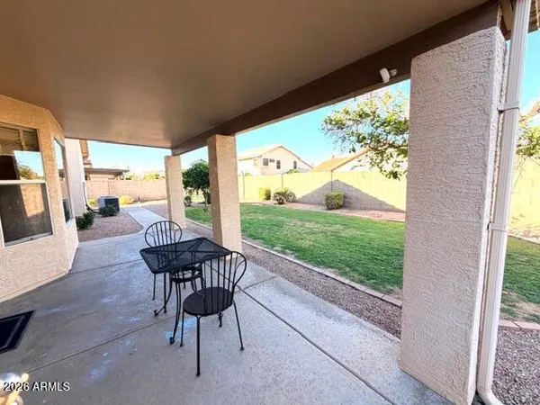 a view of a patio with a table chairs and a backyard