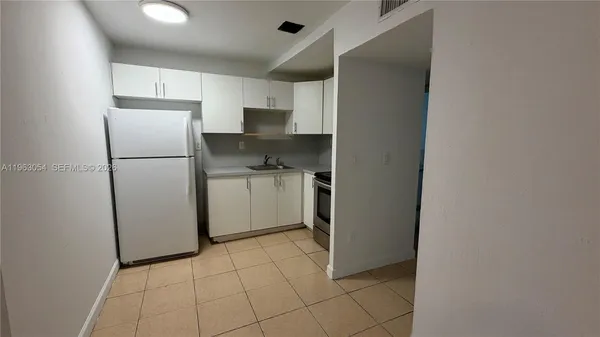 a kitchen with a refrigerator a microwave and sink