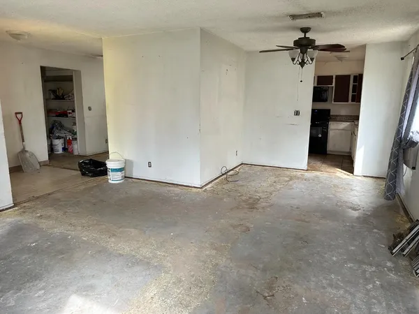 an empty room with closet and a ceiling fan