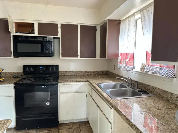 a kitchen with stainless steel appliances granite countertop a sink and a microwave