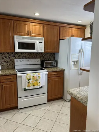a kitchen with stainless steel appliances granite countertop a stove a refrigerator and a stove