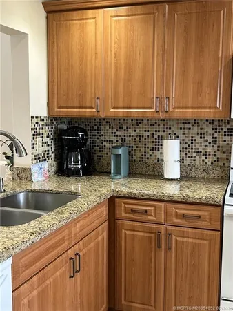 a kitchen with granite countertop a sink and cabinets