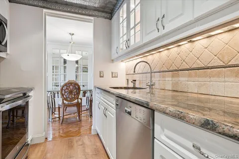 a kitchen with stainless steel appliances granite countertop a sink and a stove next to a window