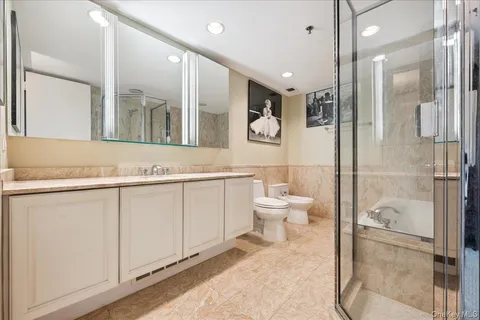 a bathroom with a granite countertop sink mirror and toilet