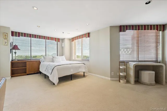 a bedroom with a bed and a large window