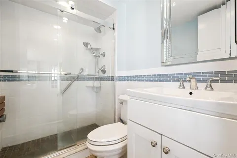 a bathroom with a sink a toilet and a mirror