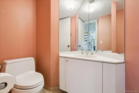 a bathroom with a toilet a sink and mirror