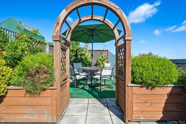 a view of a porch with a table and chairs under an umbrella