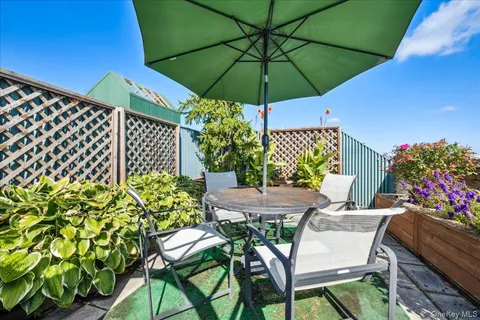 a view of a patio with furniture and a garden