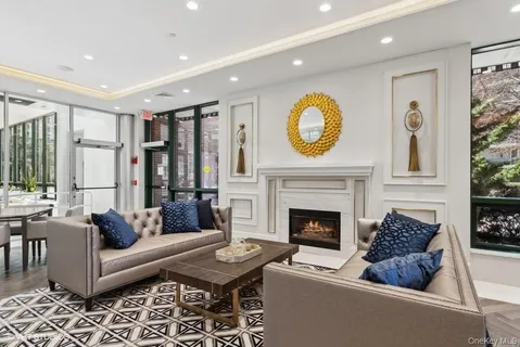 a living room with furniture a fireplace and a floor to ceiling window