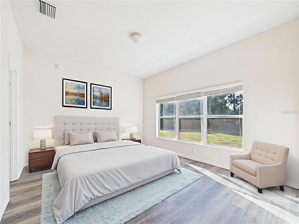 5208 Southwest 39th Street Ocala, FL 34474 - Photo 12 of 55 a bedroom with a bed and a couch with window