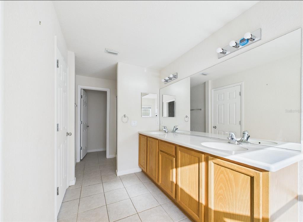 5208 Southwest 39th Street Ocala, FL 34474 - Photo 14 of 55 a large bathroom with a double vanity sink and a mirror