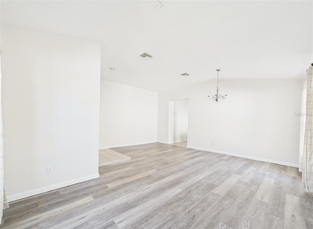 5208 Southwest 39th Street Ocala, FL 34474 - Photo 5 of 55 a view of an empty room with wooden floor