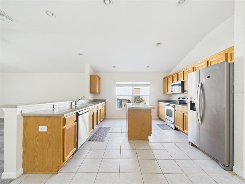 5208 Southwest 39th Street Ocala, FL 34474 - Photo 8 of 55 a kitchen with stainless steel appliances a refrigerator a stove a sink a counter top and cabinets