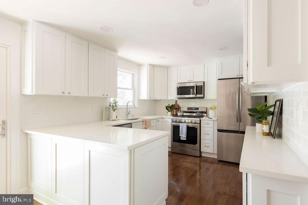 19023 Staleybridge Road Germantown, MD 20876 - Photo 14 of 36 a kitchen with stainless steel appliances granite countertop a refrigerator a stove top oven a sink and dishwasher