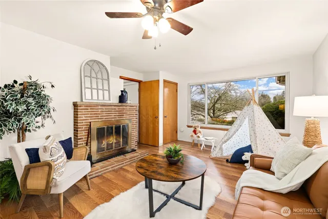 a living room with furniture a fireplace and a large window