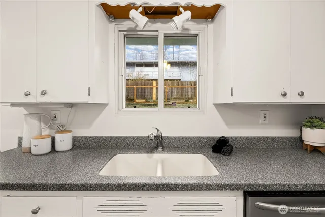 a kitchen with a sink and white cabinets