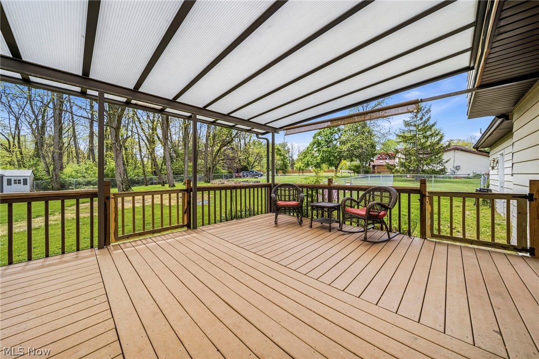 10610 Ridgewater Drive Painesville, OH 44077 - Photo 2 of 23 Expansive composite deck featuring a slatted roof cover, wood railings, and a gate