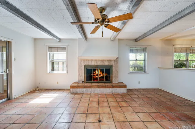 a view of a livingroom with a fireplace and window