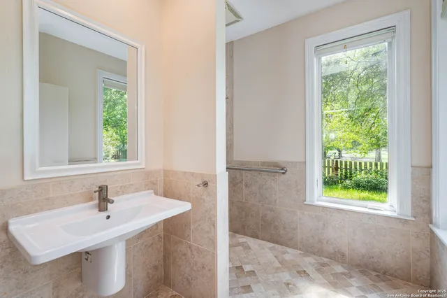 a bathroom with a sink a vanity and a window