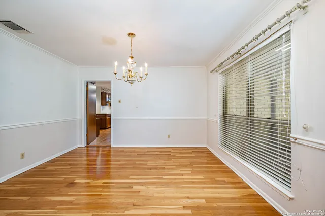 a view of a room with wooden floor and chandelier