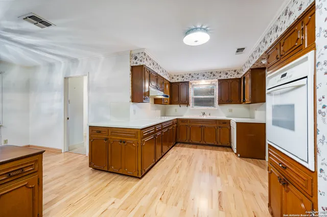 a large kitchen with stainless steel appliances granite countertop a stove a sink dishwasher and a refrigerator
