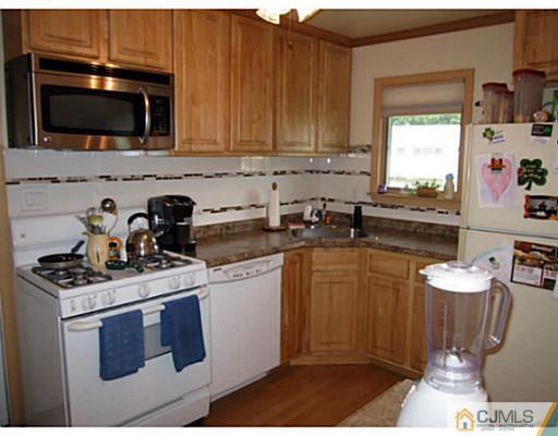 19 Wellesley Road Old Bridge, NJ 08859 - Photo 8 of 25 a kitchen with stainless steel appliances a stove a sink a microwave and cabinets